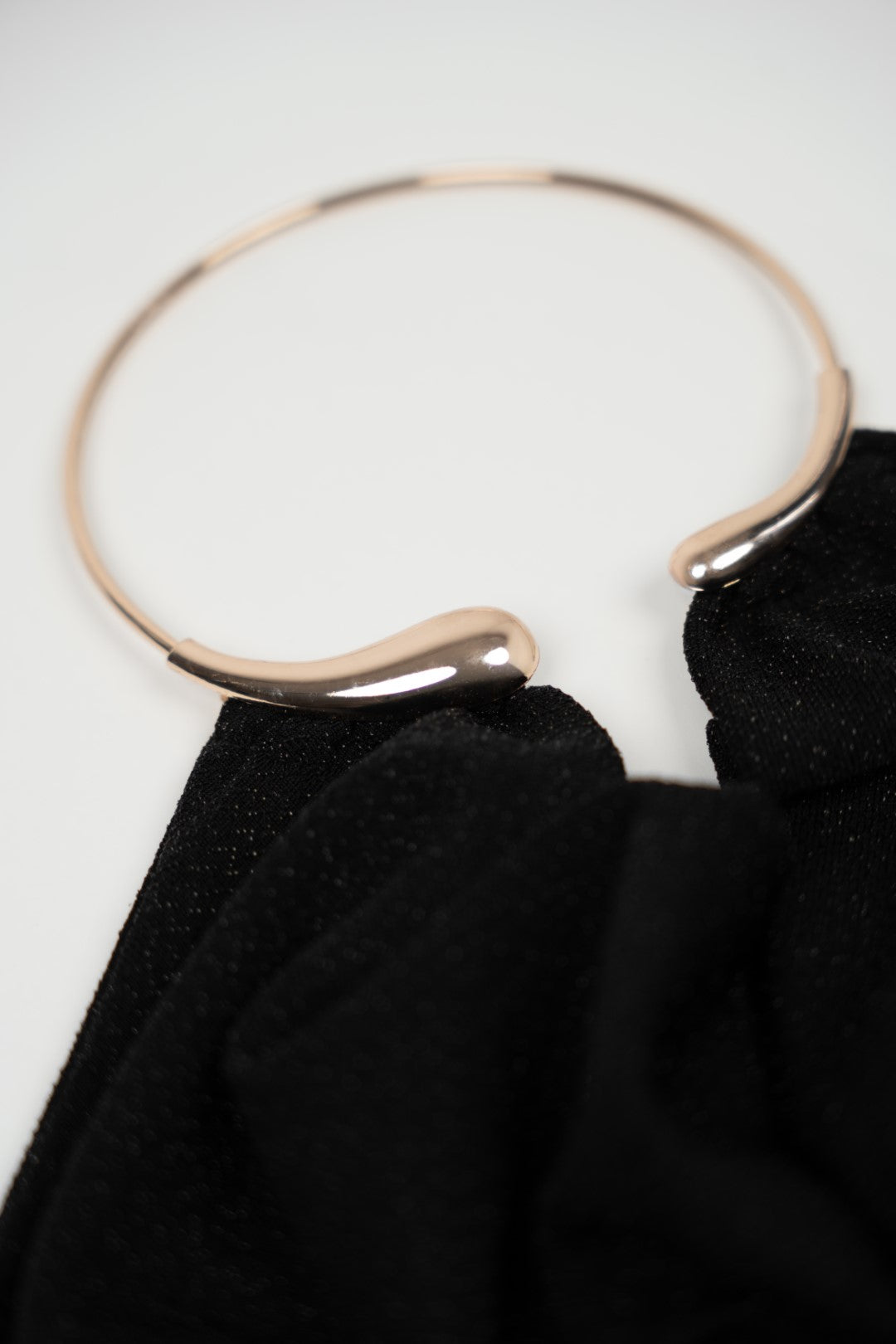 Long black dress with gold choker.