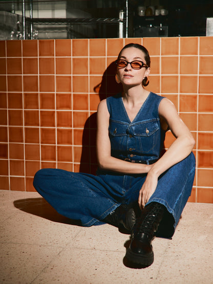 Tuta in denim scuro con cintura inclusa.