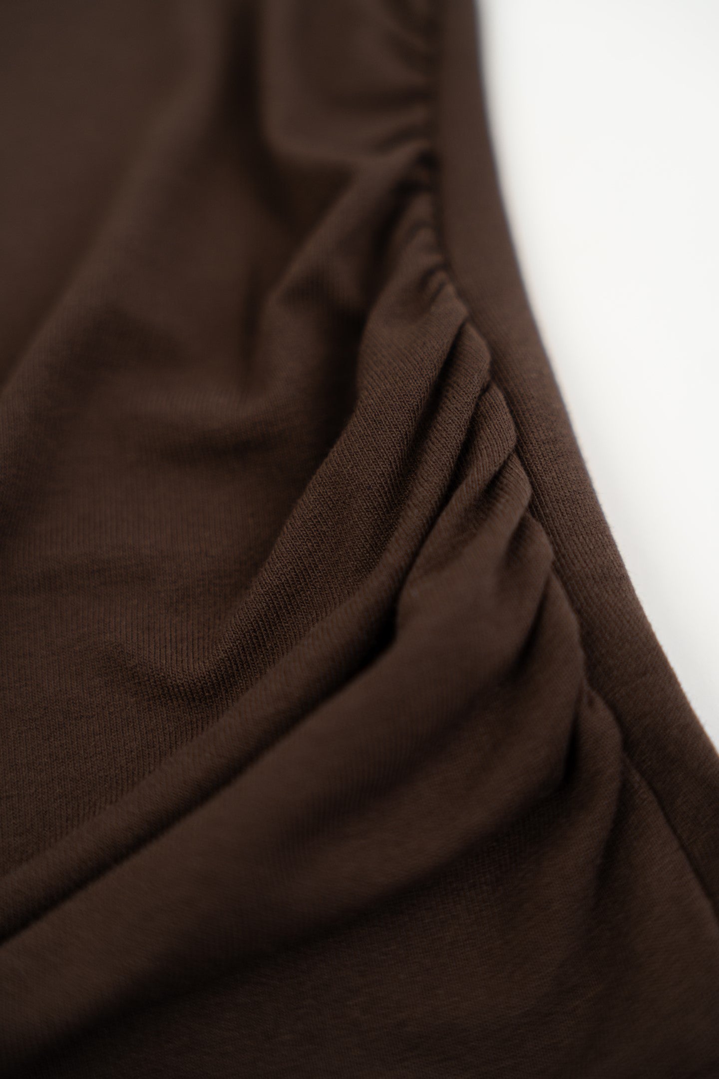 Czekoladowa koszulka z koronkowymi zdobieniami.