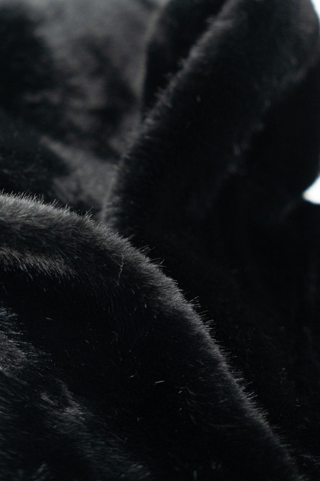Cappotto di pelliccia nero con cappuccio.