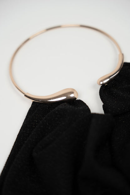 Long black dress with gold choker.