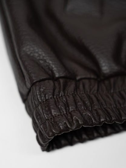 Faux leather jacket with brown collar detail.