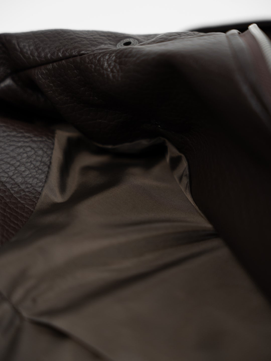 Faux leather jacket with brown collar detail.