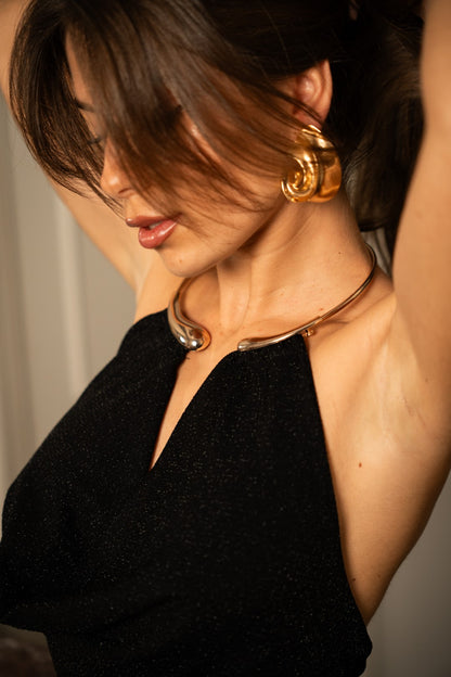 Long black dress with gold choker.