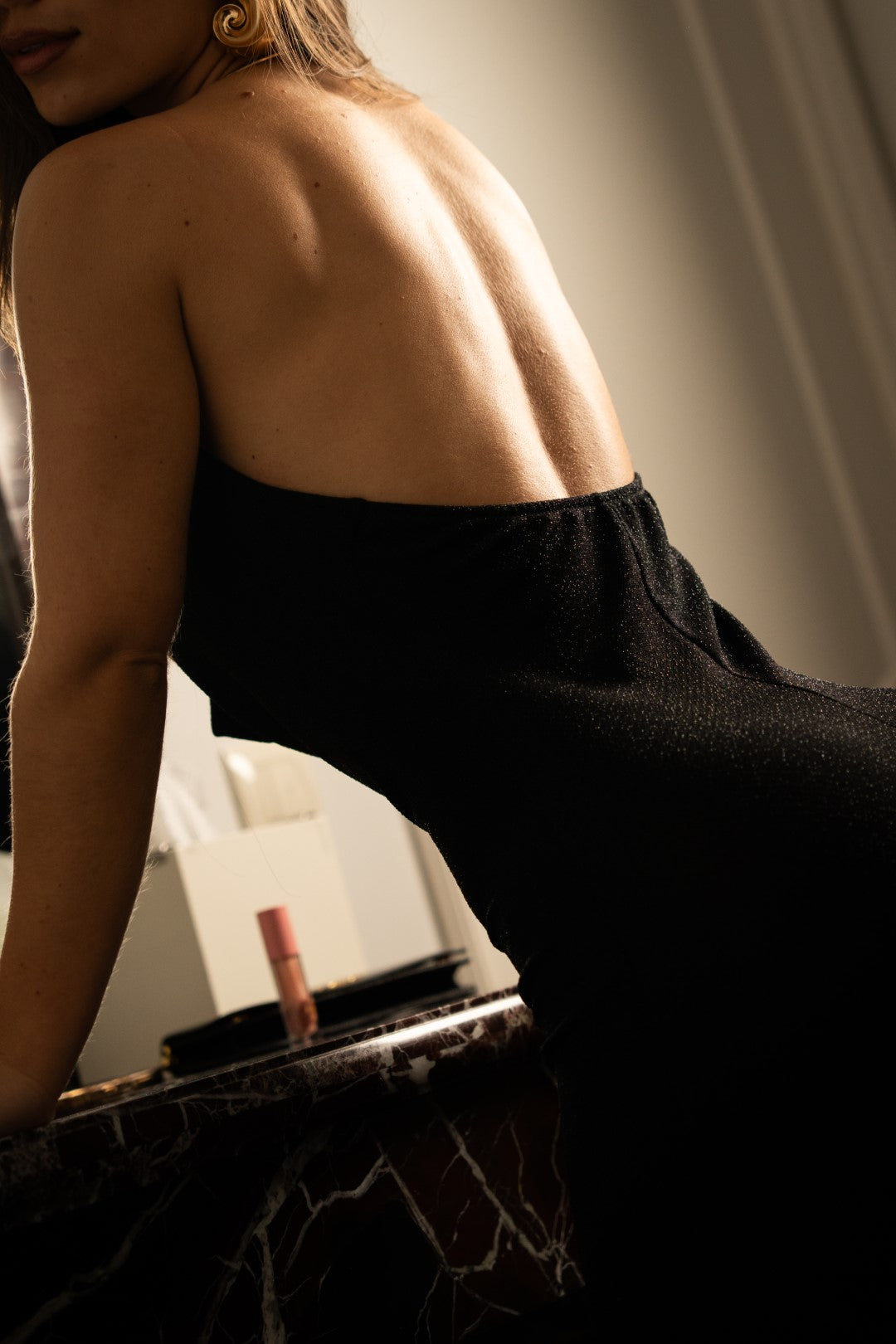 Long black dress with gold choker.