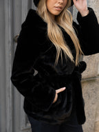 Cappotto di pelliccia nero con cappuccio.