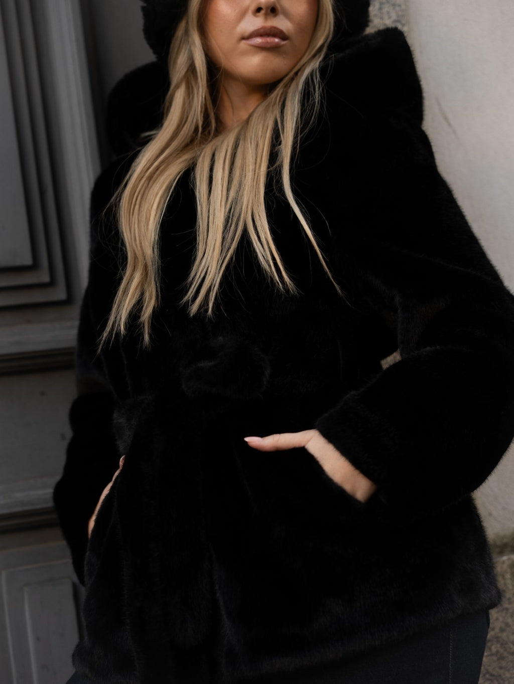 Cappotto di pelliccia nero con cappuccio.