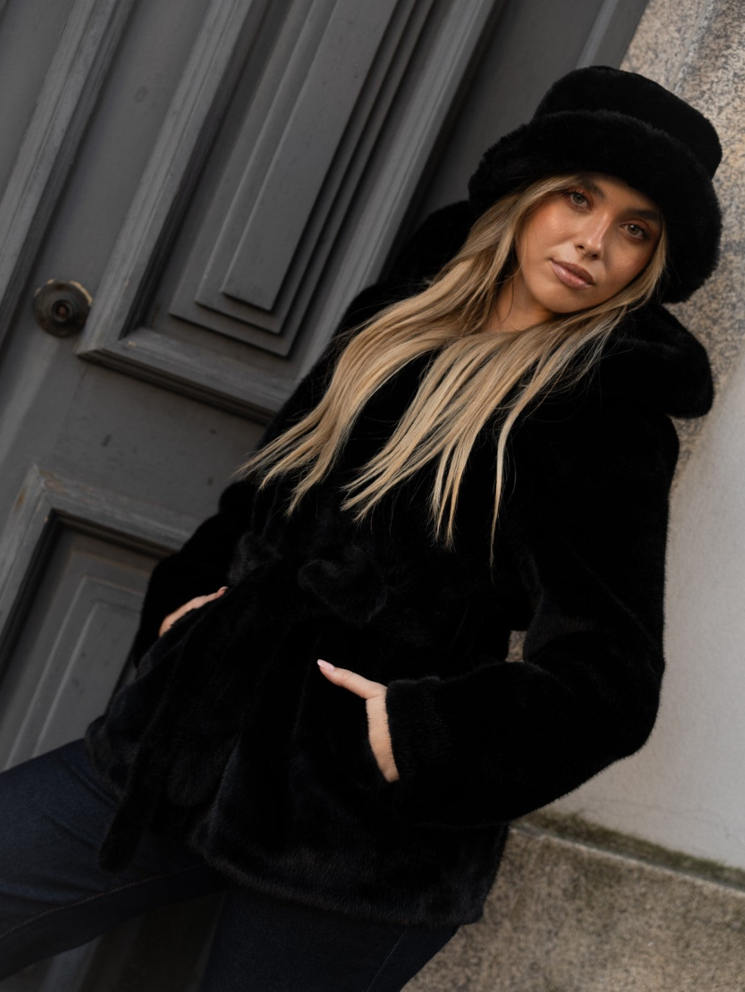 Cappotto di pelliccia nero con cappuccio.