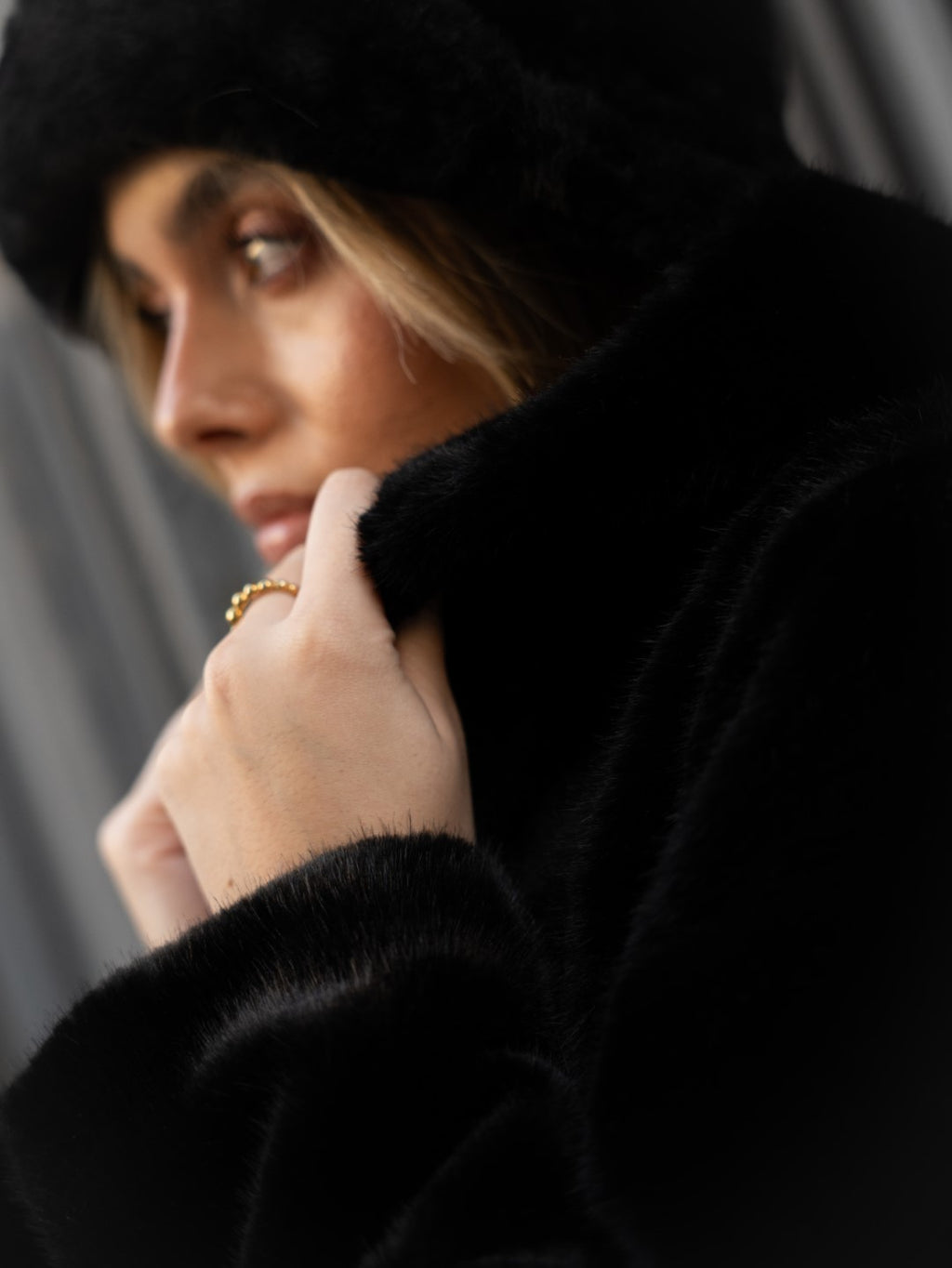 Cappotto di pelliccia nero con cappuccio.
