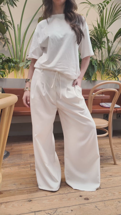 Pantaloni bianchi a gamba larga con pieghe